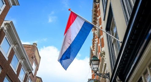 Netherlands flag on fasad building against Blue Skyin the center of Hague